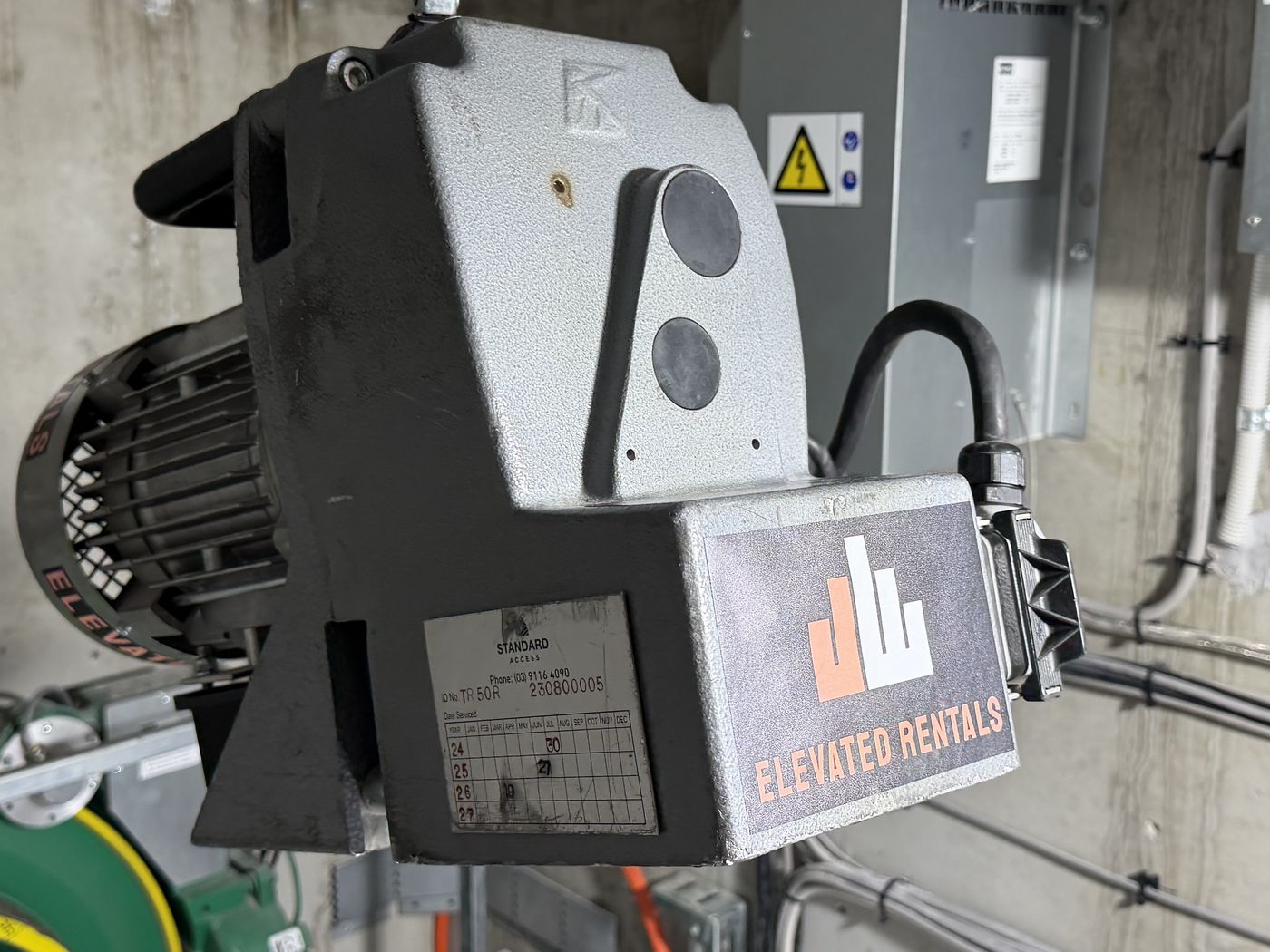 Elevated Rentals branded Tirak TR50R traction hoist showing its service inspection tag